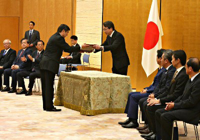 記念盾を授与される野村理事長